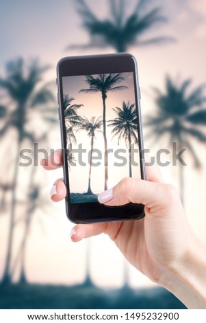 Young woman taking photos by phone on vacation. Smartphone instead of traditional camera.
