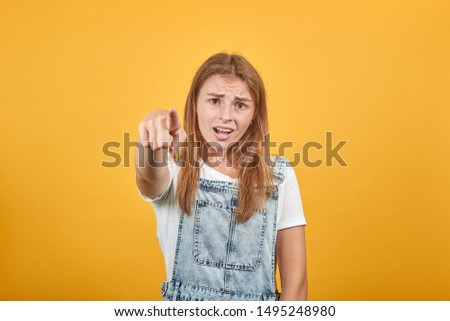 Young woman wearing white t-shirt, over orange background shows emotions