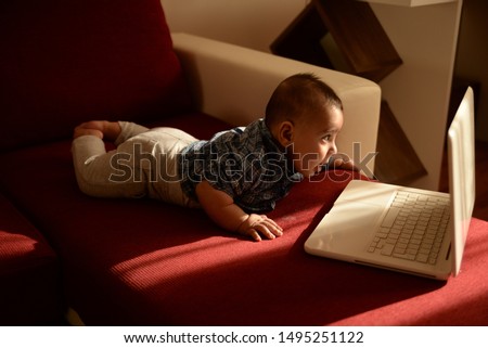 Children experiencing technology at a very young age concept, baby during tummy time having screen time