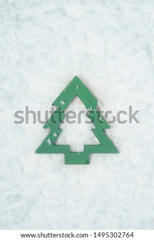 Wood toy in christmas tree shape  on snowy background. Christmas symbol, winter celebration concept.