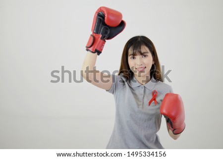 Asian woman is wearing red boxing gloves and having res ribbon (Aids symbol) on white isolated background