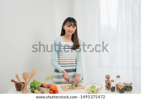 Young woman cutting vegetables in the kitchen. Woman cooking healthy food. 