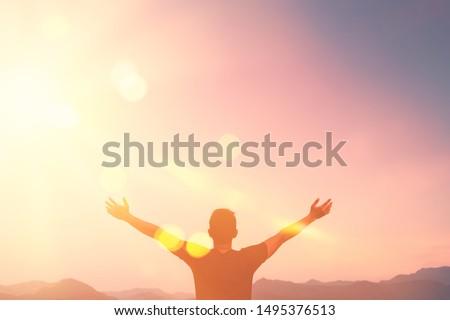 Copy space of man hand raising on top of mountain and sunset sky abstract background. Freedom travel adventure and business victory concept. Vintage tone filter effect color style.