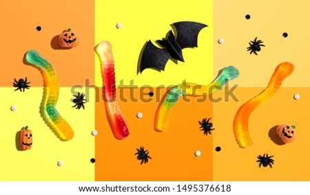 Halloween objects with gummy worms - overhead view flat lay