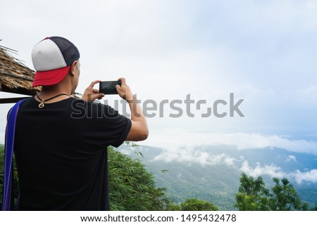 Man tourist is taking photo view of blue sky at Mon Cham, Chiang Mai, Thailand.