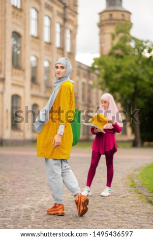 Walking to friend. International muslim woman wearing hijab walking to her friend