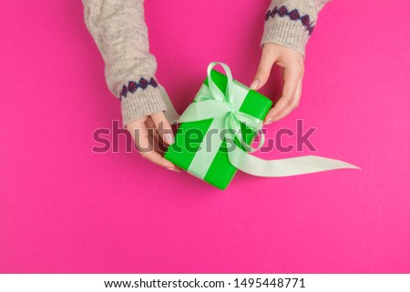 Small gift box in female hands, view from above