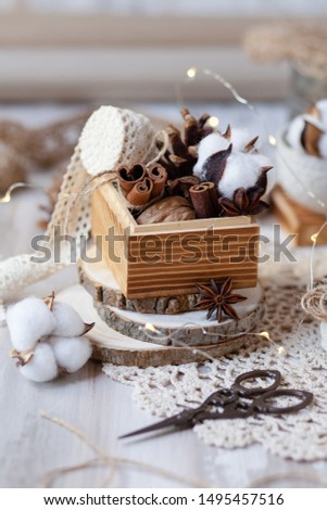 Family time to wrap christmas presents! Ideas for hand made gifts decoration in rustic style, natural ingredients, cozy mood. Wooden background, scissors, rope, lace, cones, cinnamon and cotton