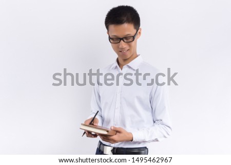 a young male holding a notepad in his hand