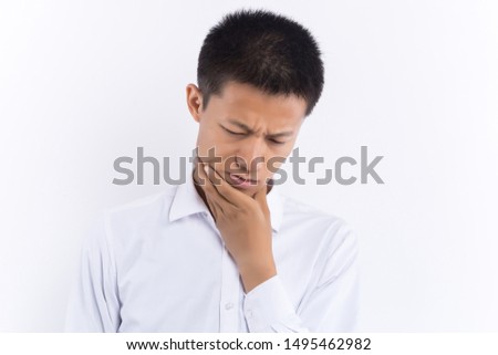 An Asian young male is touching his face