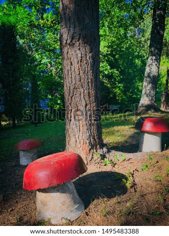 Giant three decorative mushrooms with red heads in the backyard. Garden decoration.Vertical background image.