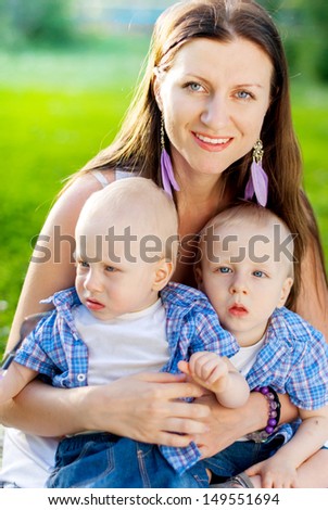 Happy family, Young Mother with her twins sons having fun at the park