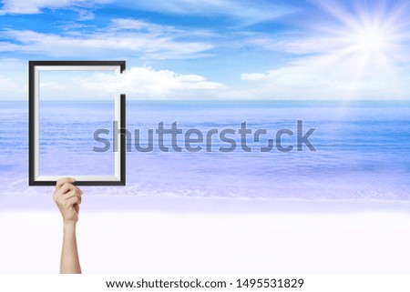 Summer Vacation Concept : Abstract image of Hand holding picture frame with beautiful seascape view in background.
