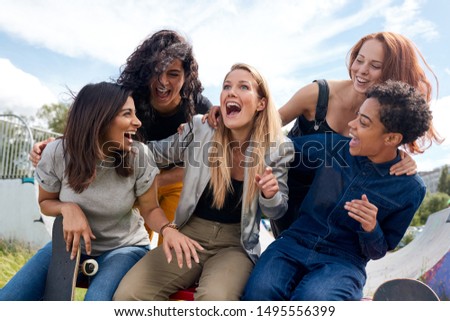 Group Of Female Friends With Skateboard Meeting In Urban Skate Park