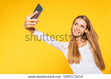 Blonde young attractive woman with smartphone. Selfie photo on cellphone. Happy picture