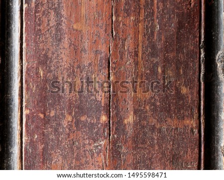Old peeling brown paint on a wooden surface