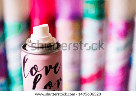 Spray nozzle in a metal cylinder with inscription love. Close up view and colorful blurred background.