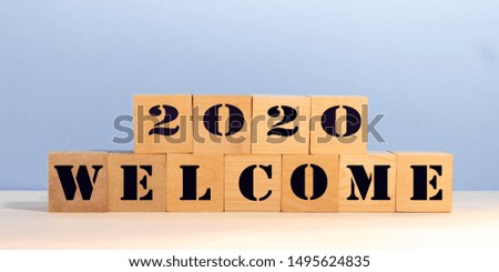 Welcome 2020 on wooden blocks with blue background