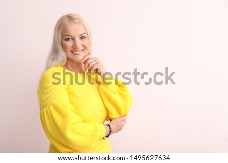 Happy mature woman on light background