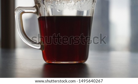 A cup of coffee on the table with city view background.