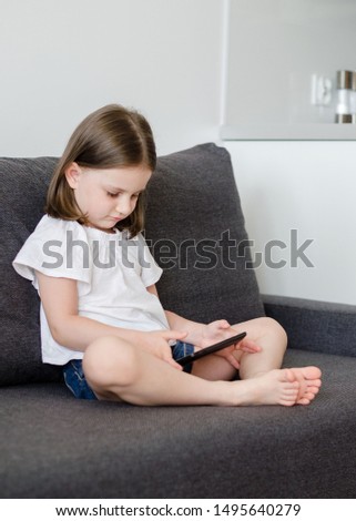 little girl 4 years old watching cartoons on a tablet