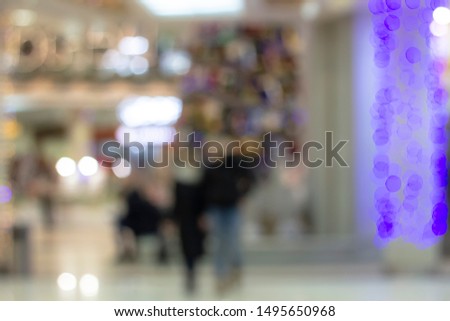 Bokeh-style photography in a Mall with people between shops with decorated shop Windows