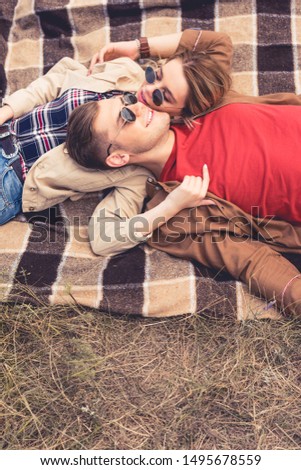 attractive woman and handsome man hugging and lying on blanket 