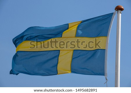 Swedish flag waving on the wind against blue sky
