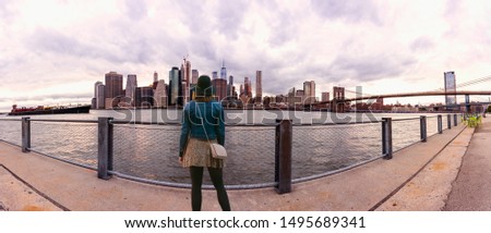 Rear view of woman looking at city view while standing on observation point.New York city NYC summer travel tourist woman enjoying view of Manhattan skyline 