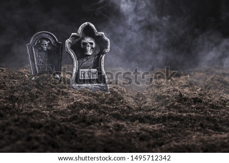 Tombstones on night cemetery in fog