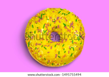 Sweet yellow donut with multicolored sprinkles on a pink background flat lay stock photo