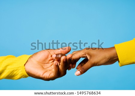 United hands Dark skin blue background yellow sweater