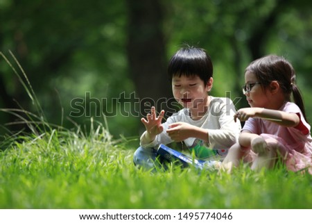 Brother and sister are playing with grass