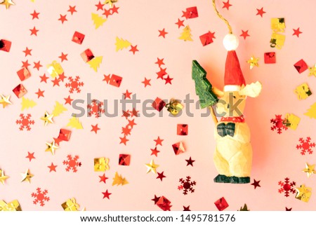 Toy wooden Santa Claus with new year tree on a pink starry background. Christmas magic concept