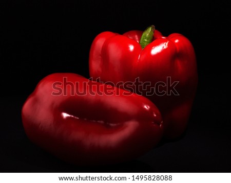 Two red sweet peppers paprika on a black  background close up