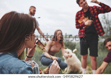 Focused photo. Group of people have picnic on the beach. Friends have fun at weekend time.