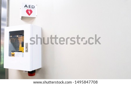 automated external defibrillator in emergency box with symbol AED on white background