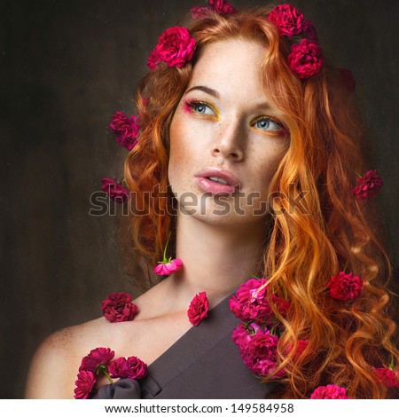 Portrait of red-haired girl with flowers in the head