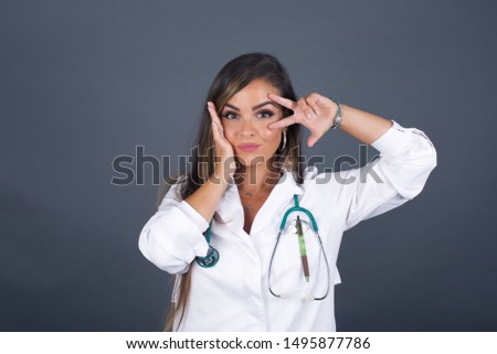 Leisure lifestyle people person celebrate flirt coquettish concept. Beautiful doctor woman showing v-sign near eyes wearing casual clothes standing against gray wall.