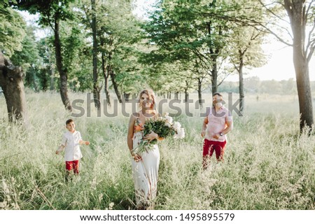 a woman holds a peony bouquet and a father with a son stand on the sides