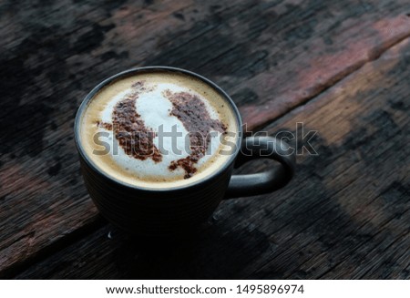 Top view image of a blue cup of hot latte coffee with latte art on vintage wooden table in cafe 