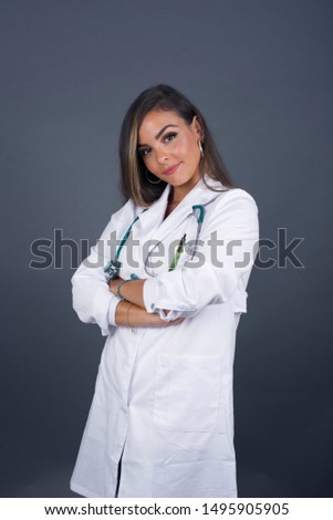 Waist up shot of beautiful self confident cheerful young doctor woman entrepreneur has broad smile, crosses arms, happy to meet with colleague, medical uniform fashionable clothes.