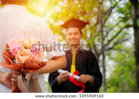 Pictures of the graduation ceremony.The young mother's mother put a bouquet of flowers behind to surprise her child.