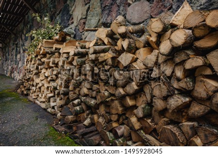 a pile of wood neatly stacked against the wall.