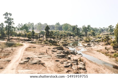 Dying rivers of a Narmada tributary in Madhya Pradesh on a scorching hot April afternoon. Dry land depicting a drought. A typical natural arid climate scenery in the rural India in a Hot Summer Day. Royalty-Free Stock Photo #1495959755