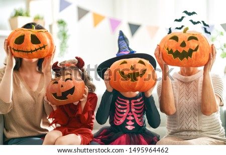 Happy family celebrating Halloween. Grandmother, mother and children at home.                                Royalty-Free Stock Photo #1495964462