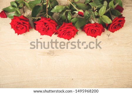 beautiful red roses on the wooden desk