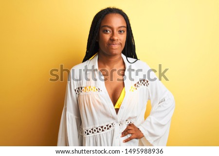 Young beautiful african american woman wearing summer casual shirt standing over isolated yellow background