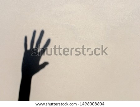 Shadow of a hand on a light wall. Freehand shadow 