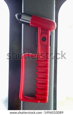 Red emergency safety hammer or glass breaker for window on a bus